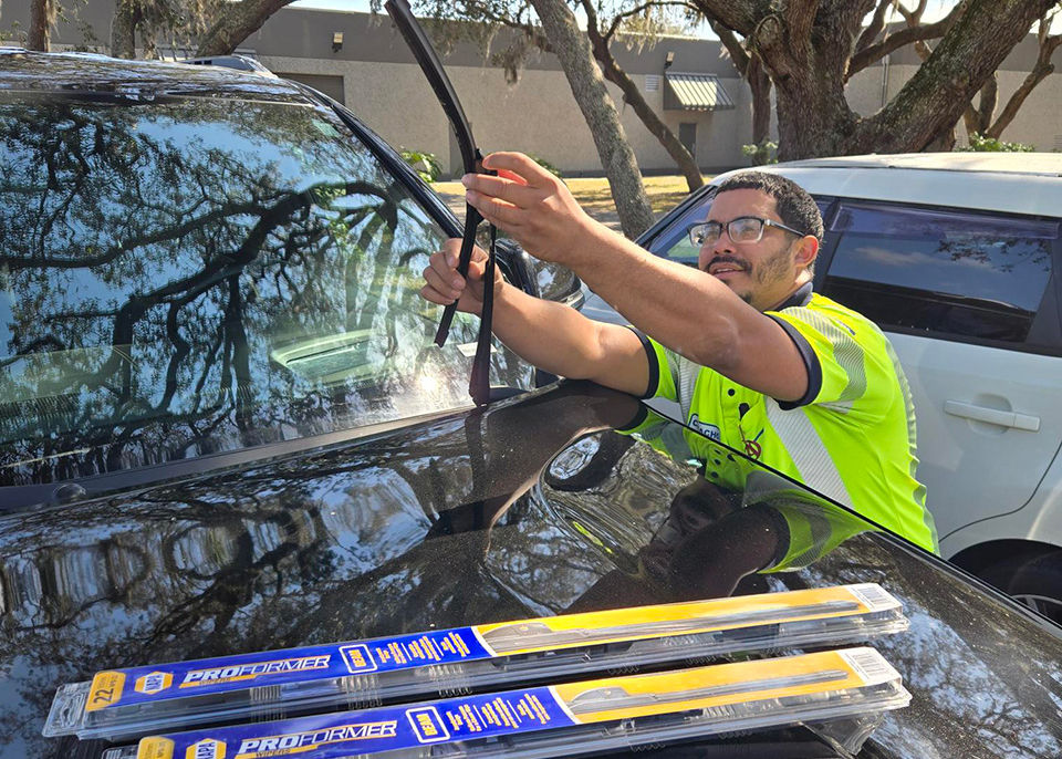 AAA technician assisting with wiper blade installation in the field