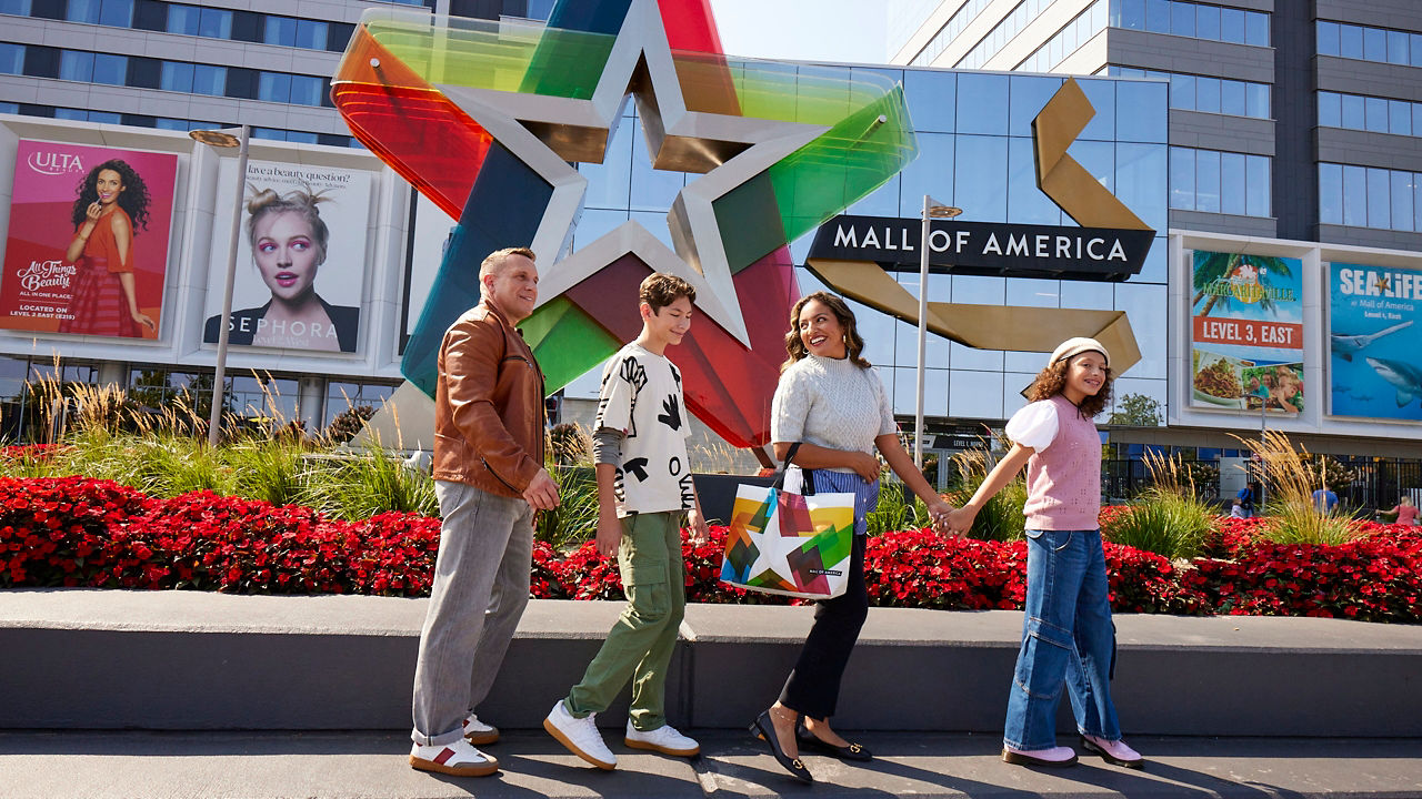 People in front of Mall of America sign.
