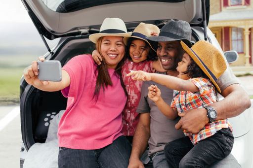 Family taking a selfie in front of car