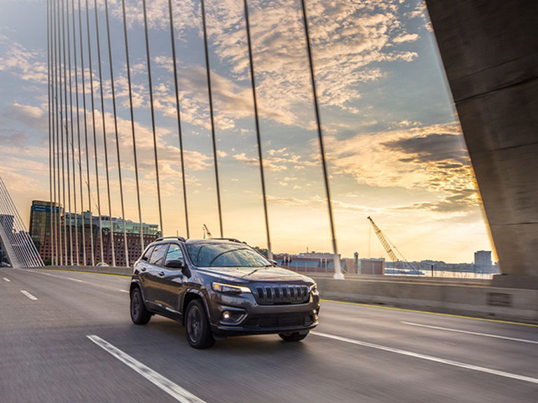 Hertz Jeep rental vehicle on a bridge at sunset.