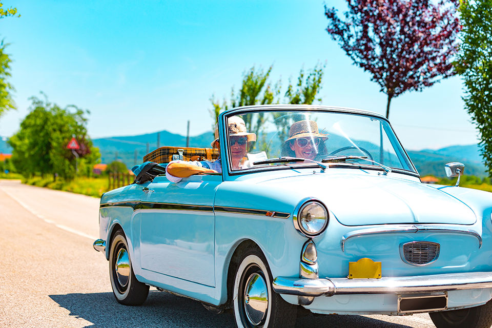 Mature Couple on a Road trip with a Vintage car.