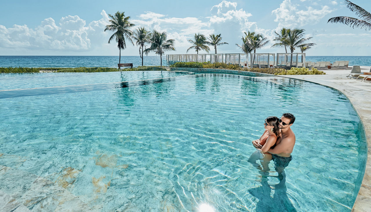 Couple enjoying all inclusive beach vacation booked with AAA