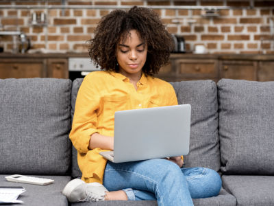 A woman sitting and using her laptop.