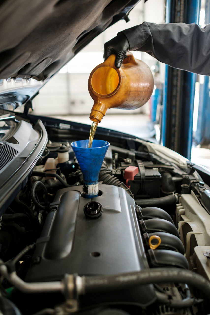a person changing the oil of a car.