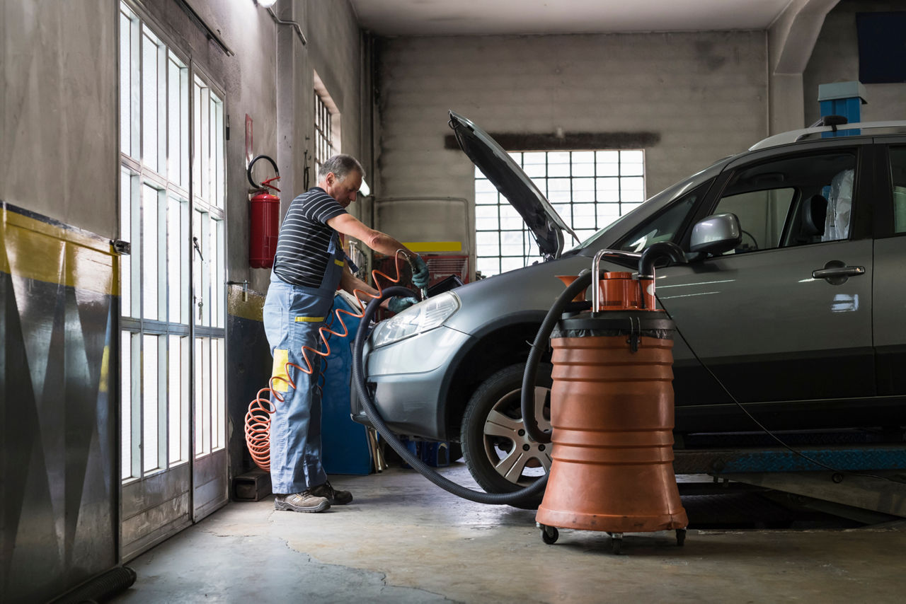 mechanic jump starting a battery in the car