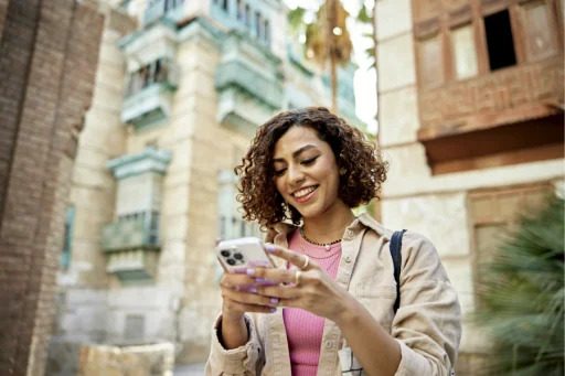 Women smiling at her phone outside