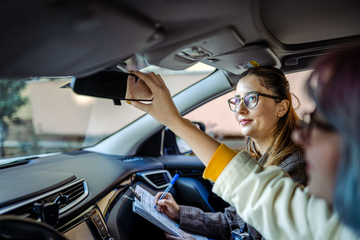 Teenager girl having driving lesson with female instructor