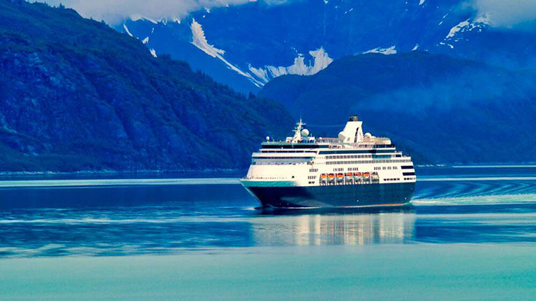 Cruise ship in bay surrounded by snow topped mountains