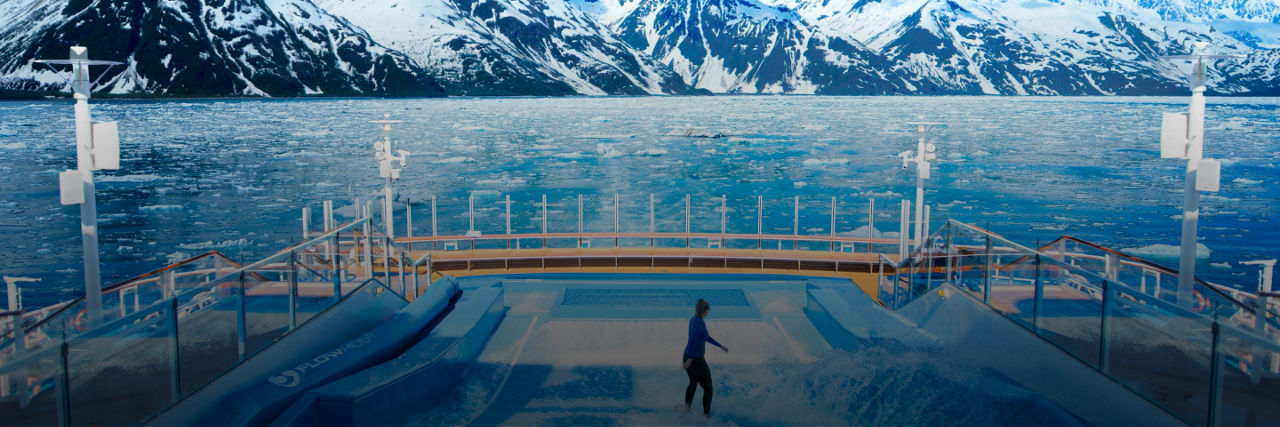 Woman on Royal Caribbean cruise ship in the surf pool in Alaska looking at mountains