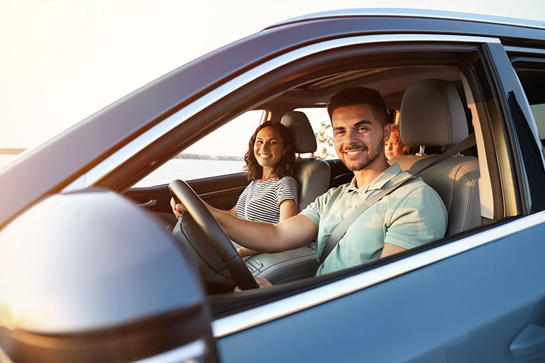 Happy family traveling by car on summer day.