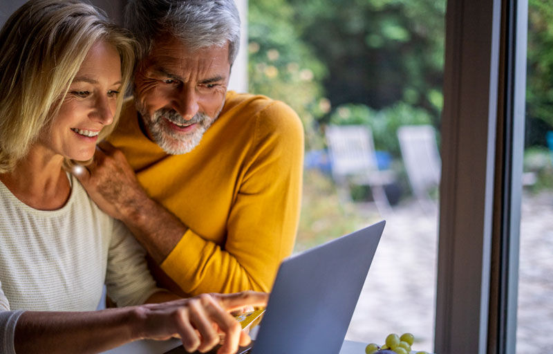 Man and Wife viewing info on a laptop at their home