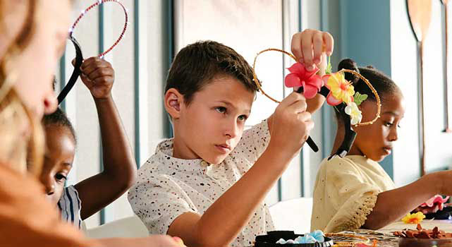 Group of children make flower mickey mouse ears.