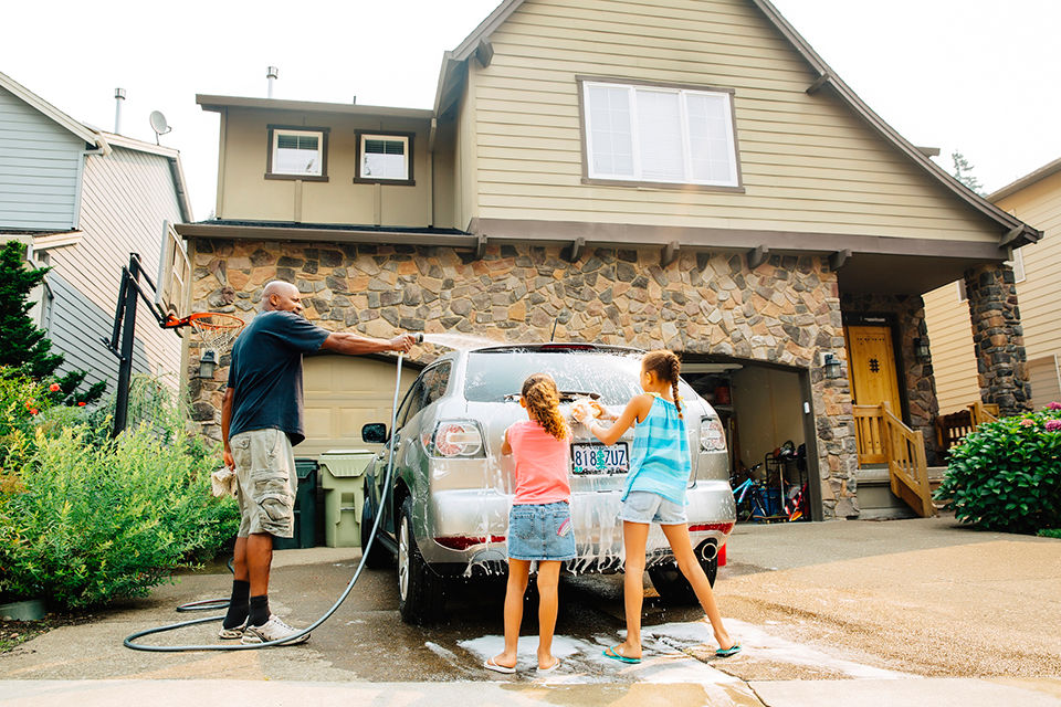 Father and daughters washing car