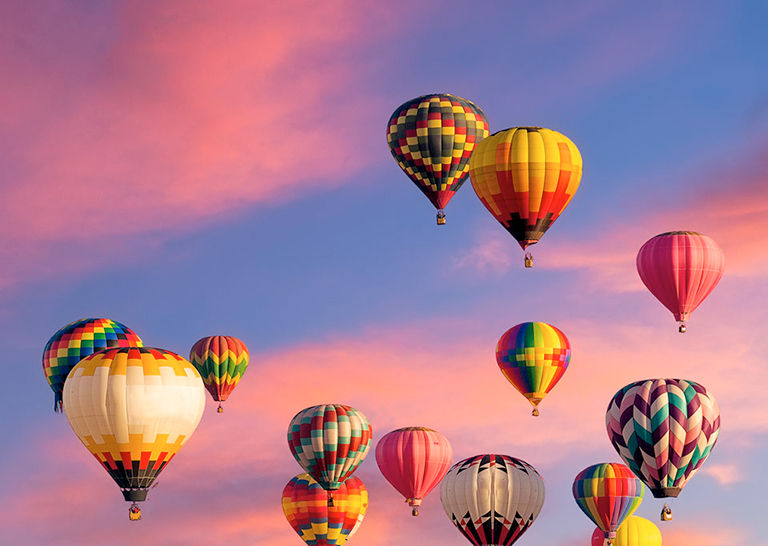 multi-colored hot air balloons filling a blue sky