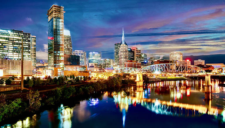 Nashville, Tennessee skyline at night refecting off the river.