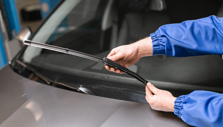 Technician is changing windshield wipers.