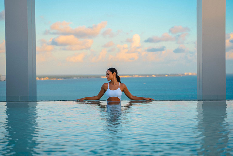 a woman in the infinity pool at a resort