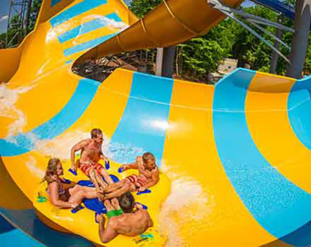Family goes down bright yellow and blue waterslide in a tube at busch gardens.