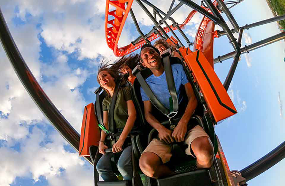Couple sits front row riding a roller coaster at busch garden .