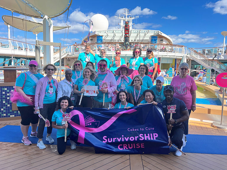 Cakes to Cure SurvivorShip Cruise passengers taking a group photo on deck.