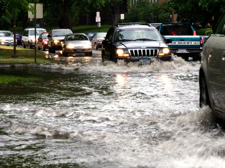 cars driving through flooded road