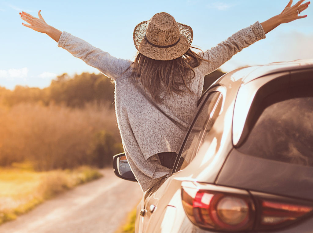 person having fun on the road out of car door