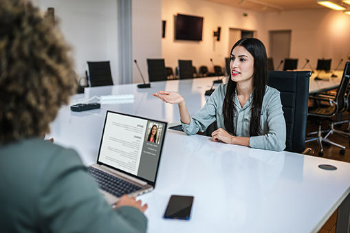 Recruiters looking at candidates cv on a laptop. Businesswoman having job interview in the office.