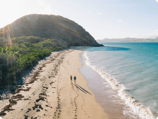 couple walking along beach on their own, Caribbean Sea alongside