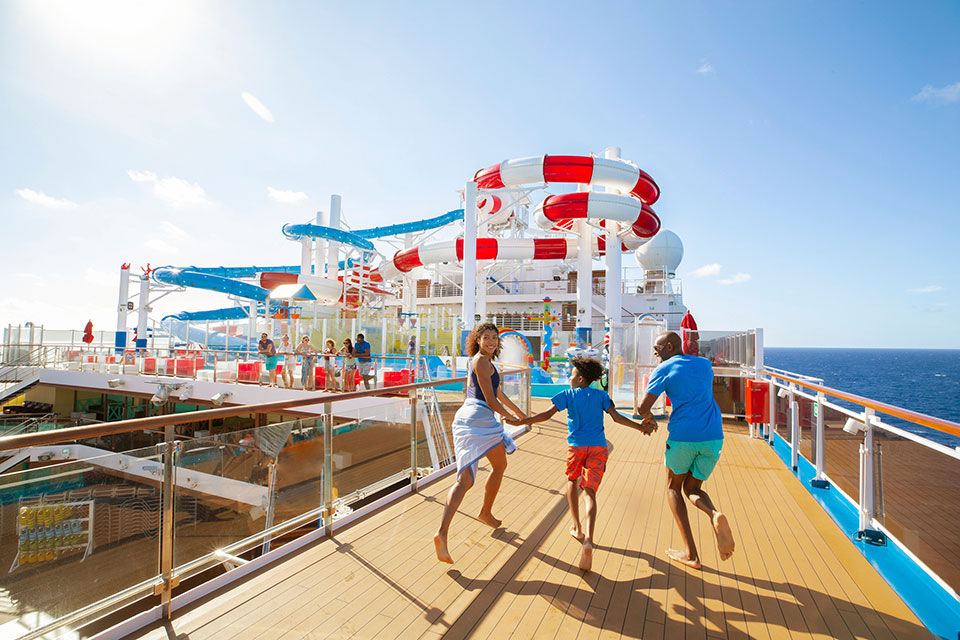 Family running towards the water park on the Carnival cruise line.