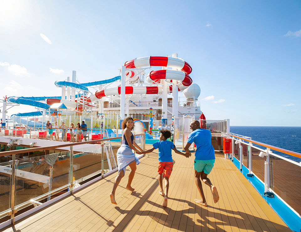 Family running to the onbaord waterpark on a Carnival Cruise