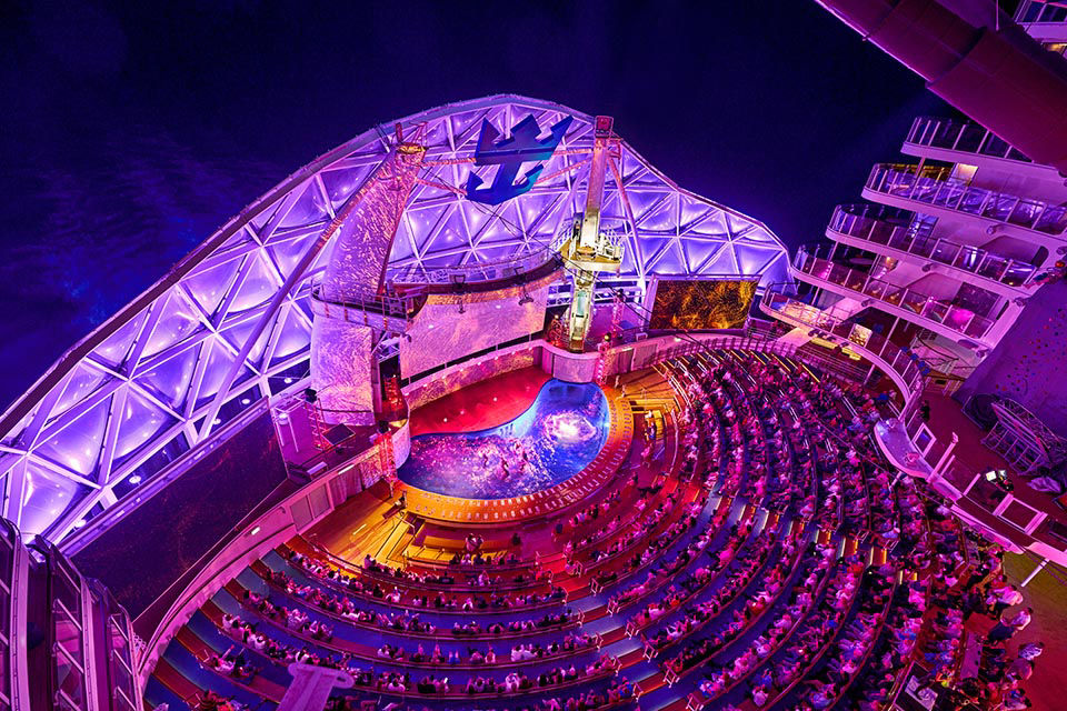 WN, Wonder of the Seas, AquaTheater, wide overview of audience and theater, night, evening show, purple and blue,