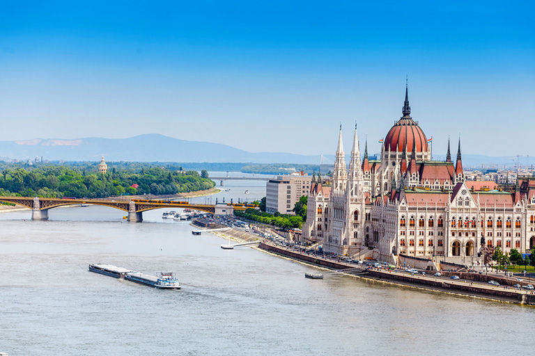 Classic view of Budapest’s iconic Parliament and the Danube with ships.