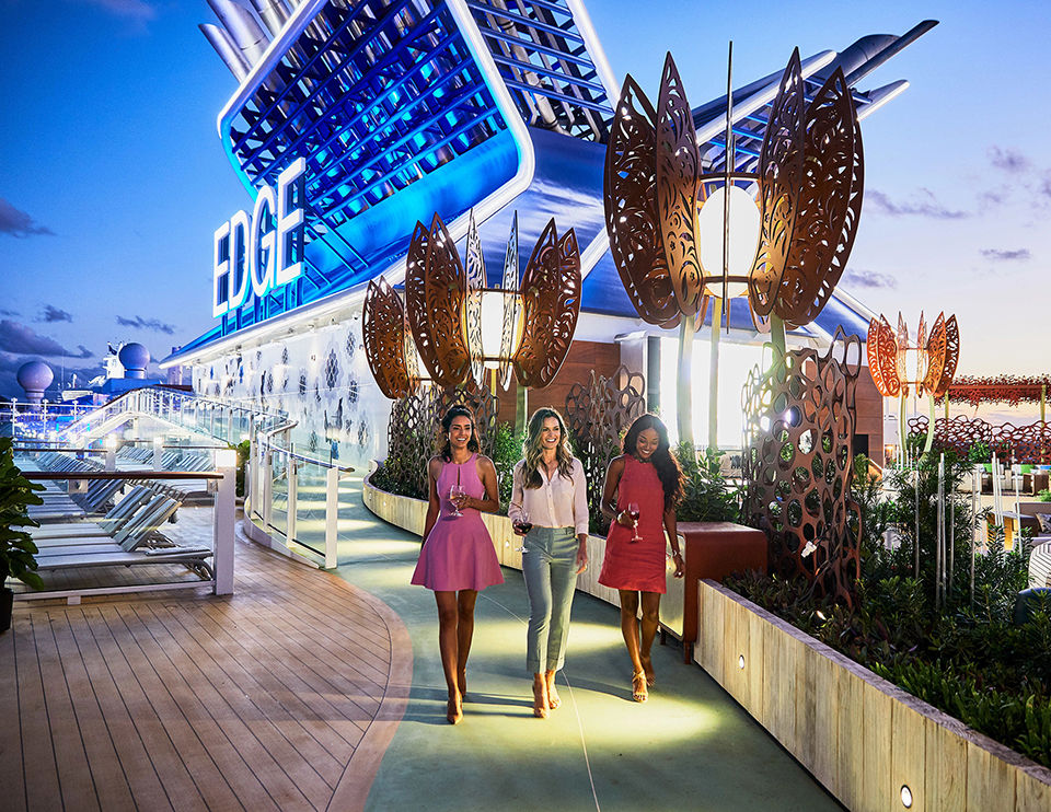 Three women walking on the deck of the celebrity edge cruise ship.