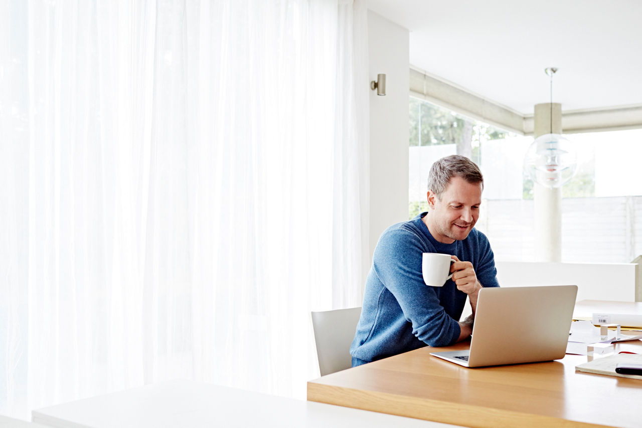 Man with coffee and laptop sitting