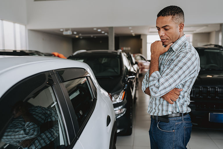 Man in showroom looking at cars
