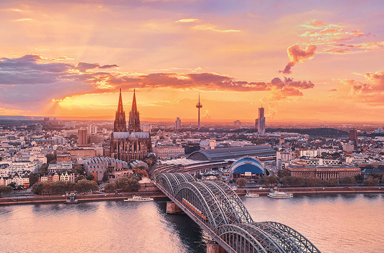 A picturesque sunset above Cologne. The Cathedral (Dom), TV Tower (Clonius), the Musical Dome,"kölner Philharmonie", the river Rhine,Hohenzollern Bridge,Museum Ludwig and Old Town are faetured beyond a colorful sky.