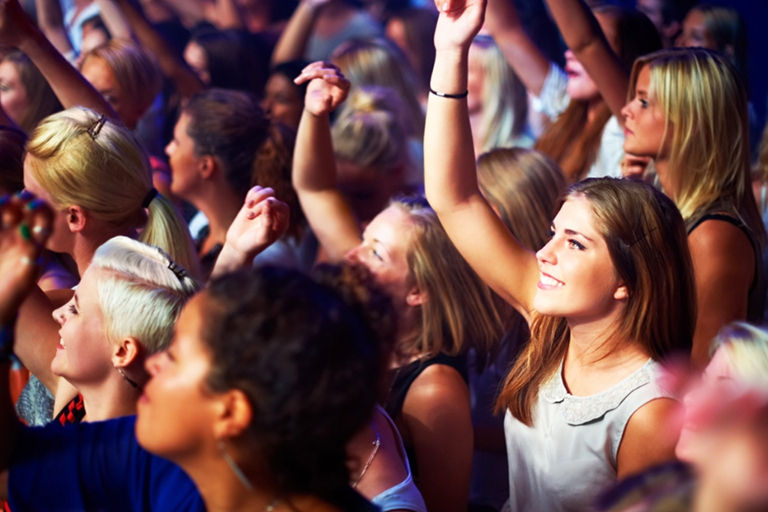 Young, happy group of fiends at a concert.