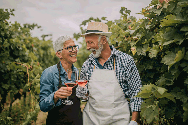 A couple enjoys a vineyard tour sharing wine and joyful moments while traveling.