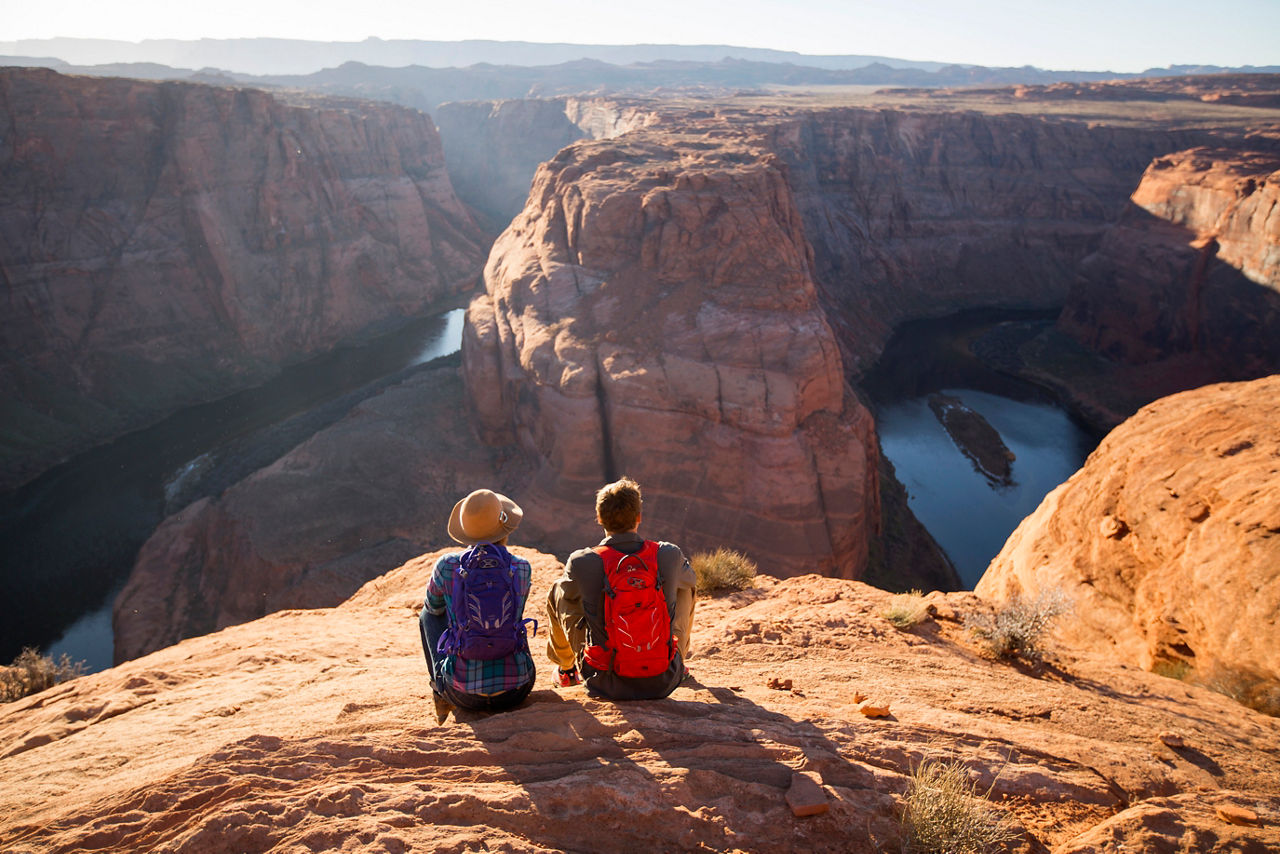 A couple sitting at an overlook at Horseshoe Bend, Arizona.