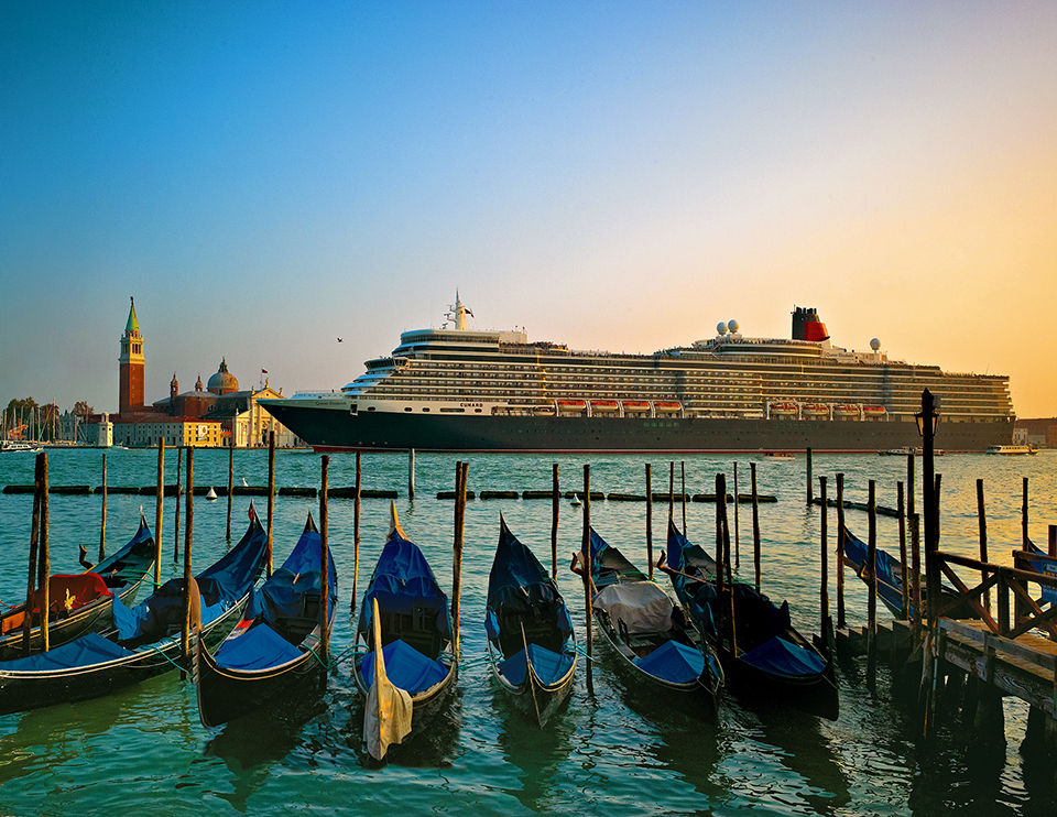 cunard cruise ship sailing near docked canoes.