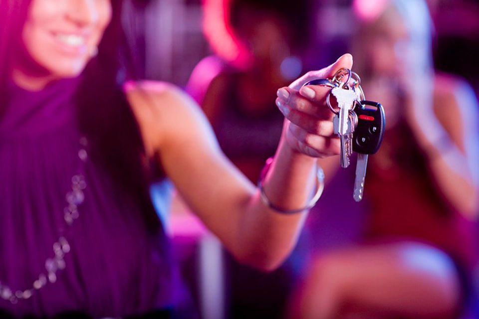 Women hands keys to a friend before having a drink.