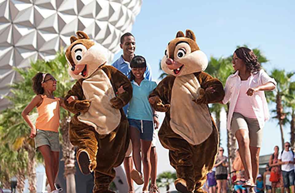 Family of four walk arm and arm with the chipmunks in epcot's park.