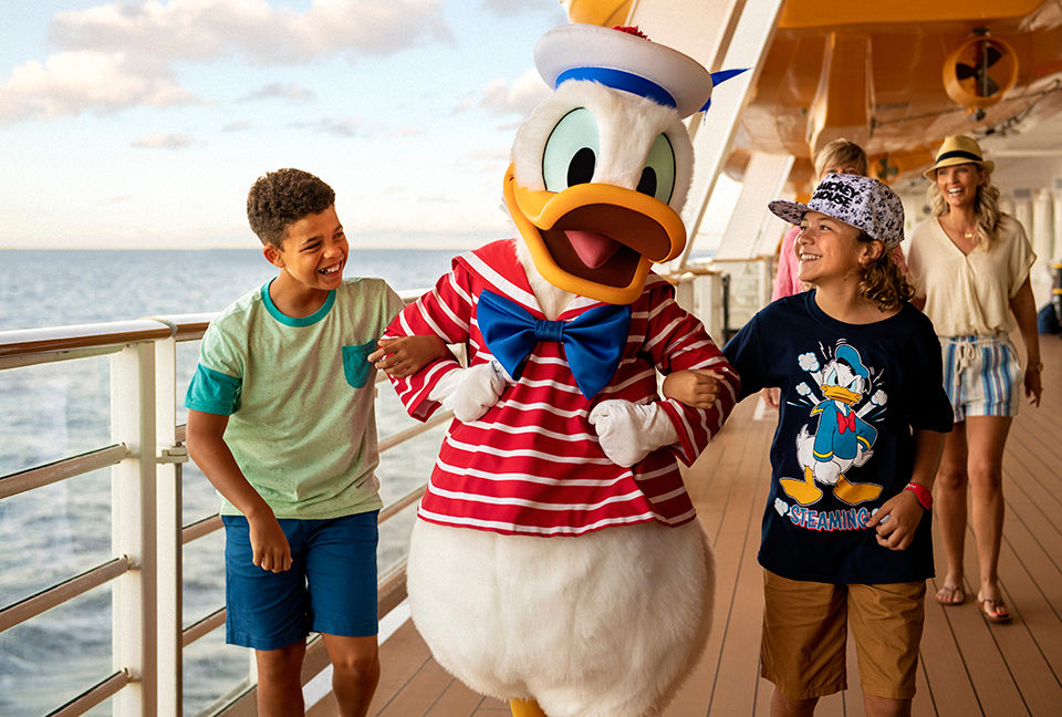 Children walking with Donald Duck on a Disney cruise ship.