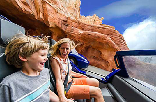 Mom and son sit inside a car ride at california adventure park.
