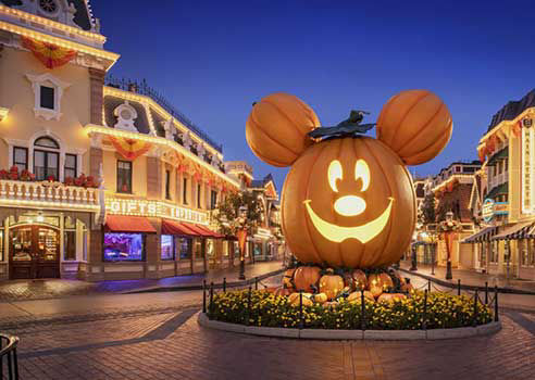 Pumpkin shaped mickey mouse lights up at night welcoming guest to the oogie boogie bash.