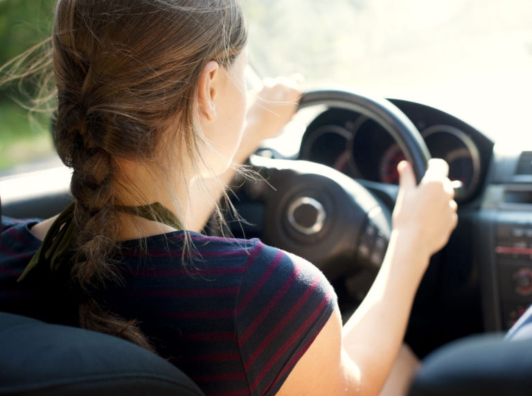 Teen girl driving a car. 