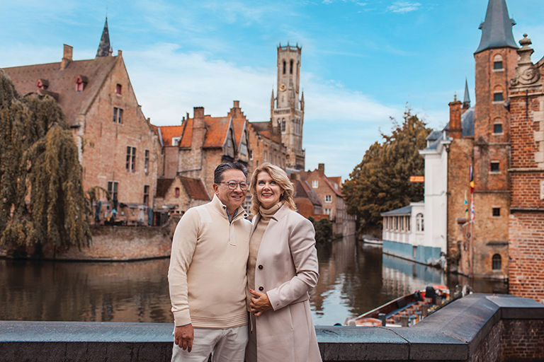 Happy, mature couple on a bridge in Bruges Belgium on vacation.