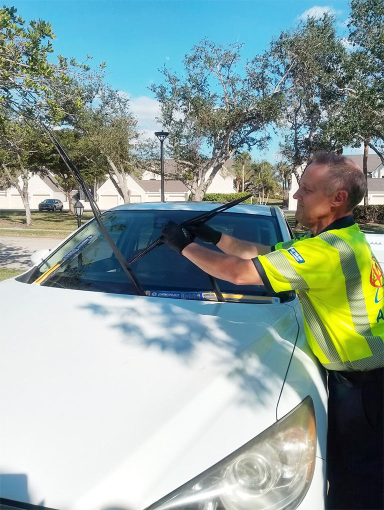 Technician changing the windshield wipers on a car.