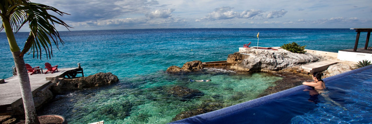 Woman relaxing in the pool oceanside in Cozumel