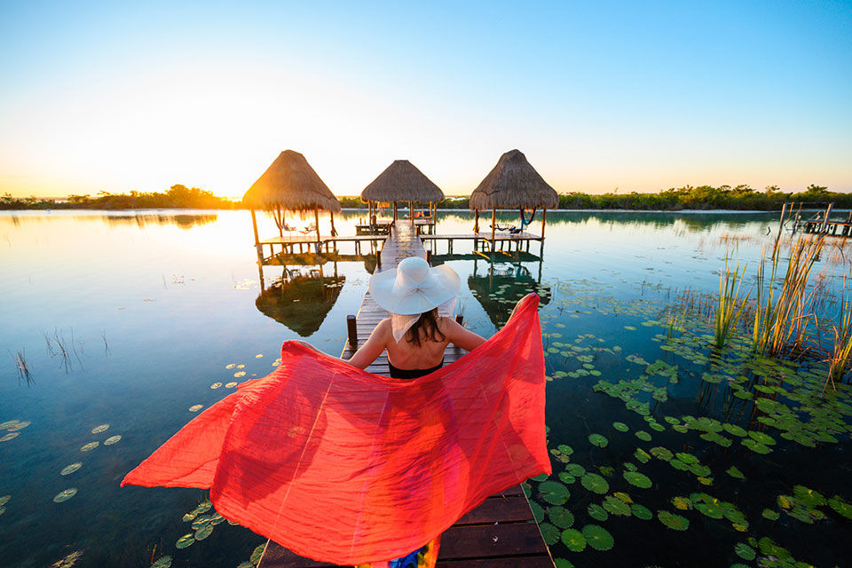 Woman playing with red sarong on a pier, Mexico.